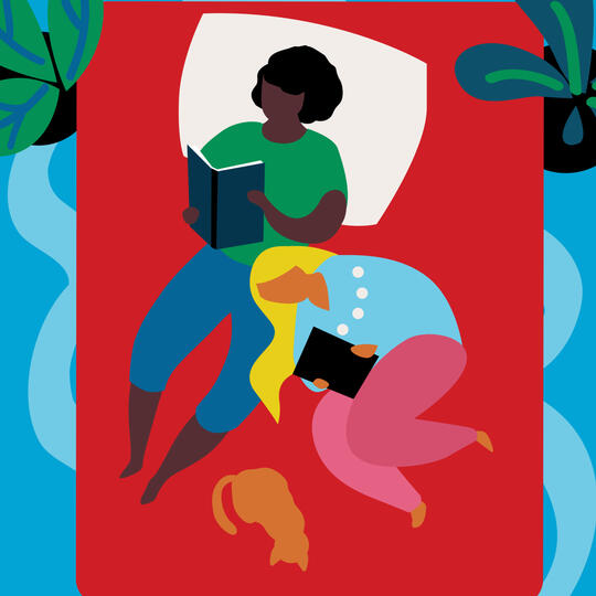 Two women reading books in bed with a cat